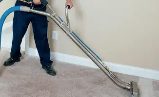 Professional operating a liquid removal machine on a carpeted floor in Mobile, AL